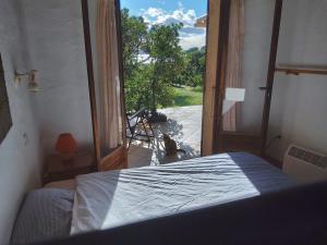 a bedroom with a bed and an open door at Villa Surleau in Zonza