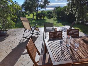 a patio with a wooden table and four chairs at Villa Surleau in Zonza +7 photos