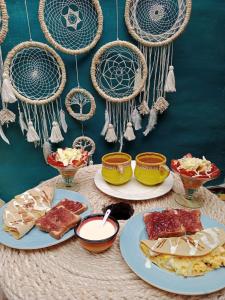 a table with plates of food on top at Bohemio Chic House - Alojamiento con vista al bosque a 45 minutos de Medellin en Santa Elena in Santa Elena