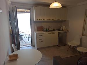 a kitchen with a table and a sink and a table and chairs at Hiona House in Angathiás