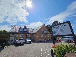 a building with cars parked in a parking lot at Pension Haus Erika in Cuxhaven