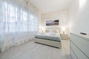 a white bedroom with a bed and a window at 15 minuti a piedi dalla stazione centrale in La Spezia