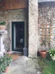a door in a stone wall with plants next to it at Gîte dans un petit village pyrénéen in Lézignan +2 photos