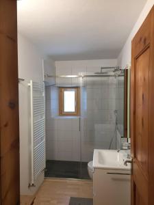 Un baño con inodoro, lavabo y ducha. en Chesa Dimvih, en Zuoz