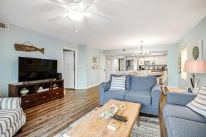 a living room with two couches and a tv at Charleston Oceanfront Villas 101 in Folly Beach