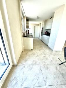 a large kitchen with white cabinets and a large tile floor at Montreux CH 4 bedrooms,4 bathrooms 8-10 pers in Arni Alp