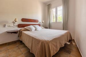 Un dormitorio con una cama en una habitación con ventana. en Can Solsulet, en Es Pujols