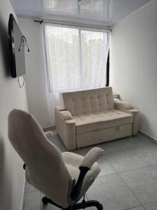 a living room with a chair and a couch at Apartamento nuevo en La Patria in Armenia +2 photos