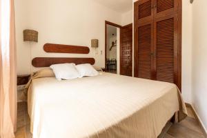 Un dormitorio con una gran cama blanca con dos almohadas. en Can Solsulet, en Es Pujols 4 fotos más