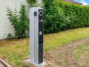 a parking meter sitting in the grass next to a house at B&B HOTEL Hannover-Garbsen in Garbsen +20 photos