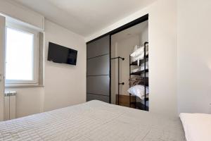 a bedroom with a bed and a tv on a wall at Tiny Loft Skydeck in Civitavecchia