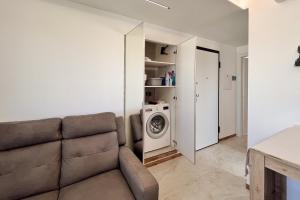 a living room with a couch and a washing machine at Tiny Loft Skydeck in Civitavecchia