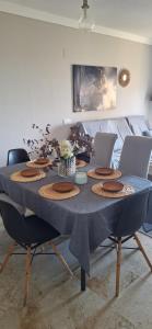 a dining room table with a blue tablecloth and chairs at Apartamento con jardin in La Línea de la Concepción +36 photos