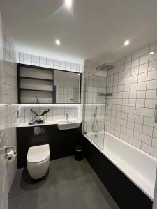 a bathroom with a toilet and a tub and a sink at Birmingham City Center View in Birmingham