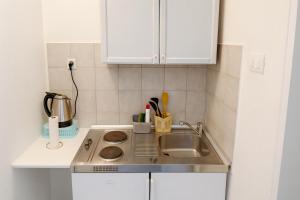 a small kitchen with a sink and white cabinets at Apartments Nikola in Gradac +21 photos