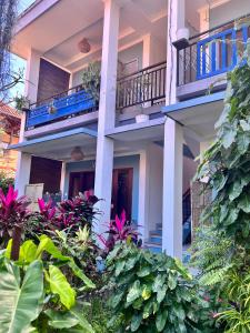 a building with a balcony and some plants at Varmana Ubud - The Blue House in Ubud