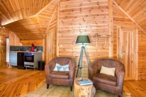 2 sillas y una lámpara en una habitación con paredes de madera en Grand Kota Avec Bain Nordique, en Saint-Cybranet 27 fotos más