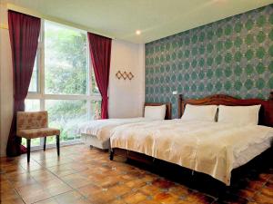 a bedroom with a bed and a chair and a window at 城市阿瑪菲-花蓮火車站前歐風民宿 in Hualien City