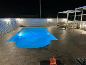 a blue swimming pool on a patio at night at u Fico du Biggiunu in Santa Domenica Talao