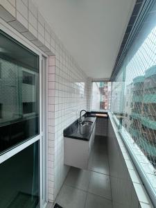 a bathroom with a sink and a large window at Vista Mar 111 in Praia Grande