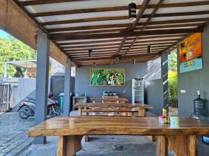 un groupe de tables en bois dans un patio dans l'établissement Sammy Cottage Senggigi, à Mangsit 62 autres photos