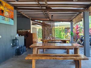 une table en bois et des bancs dans une pièce dans l'établissement Sammy Cottage Senggigi, à Mangsit