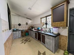 a large kitchen with a sink and a large window at Queen Bed Budget Room in Padang Serai