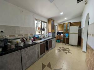 a large kitchen with many pots and pans at Queen Bed Budget Room in Padang Serai
