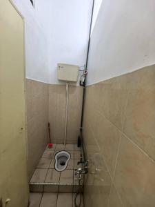 a small bathroom with a toilet in a stall at Queen Bed Budget Room in Padang Serai +8 photos