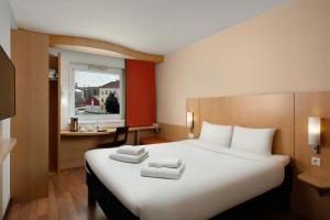 a hotel room with a large bed with towels on it at Ibis Győr in Győr +71 photos