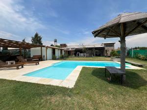 a swimming pool in a yard with an umbrella at Zafarrancho Zárate in Zárate