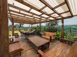 a wooden deck with a hammock and benches at Zafarrancho Zárate in Zárate