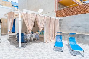 a group of blue chairs in a room with a table at Casa Belvedere vista mare in Portopalo