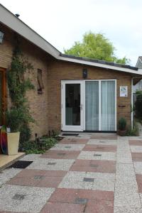 a house with a glass door on the side of it at De Strandloper Zeeland, Studio nabij strand 3km in Koudekerke