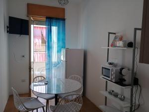 eine kleine Küche mit Tisch und Kühlschrank in der Unterkunft CarolHouse in Lido Conchiglia