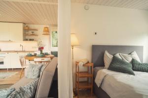 a bedroom with a bed and a table and a kitchen at Hygge House Hiiumaa in Hiiumaa