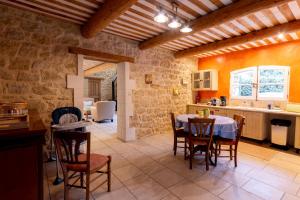 Mas des Olivades - Ferme Provençale - Piscine في بيرنيه لو فونتينز: مطبخ وغرفة طعام مع طاولة وكراسي