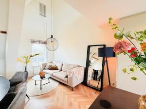 a living room with a couch and a mirror at Cooth's Luxury Loft with City Views in Breda
