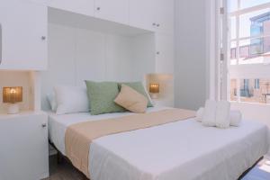 a white bedroom with two beds and a window at Brillo desde la ventana en Vigo by CABANA Rentals in Vigo