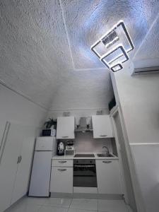 a kitchen with white cabinets and a light on the ceiling at Marinella House Napoli centro Piazza Dante in Naples +58 photos