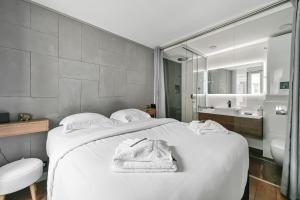 ein Schlafzimmer mit einem großen weißen Bett und ein Badezimmer in der Unterkunft Le Sorrento - 2 prs - Métro 12 - Proche Paris in Vanves