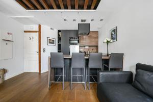 eine Küche und ein Wohnzimmer mit Tisch und Stühlen in der Unterkunft Le Sorrento - 2 prs - Métro 12 - Proche Paris in Vanves