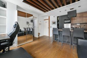 eine Küche und ein Wohnzimmer mit Tisch und Stühlen in der Unterkunft Le Sorrento - 2 prs - Métro 12 - Proche Paris in Vanves