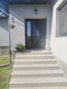 a front door of a white house with stairs at Casa crisan in Mintiu Gherlii