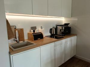 a kitchen counter with a sink and a microwave at Apartament BURSZTYNOWA 10 in Niechorze