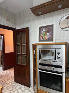a kitchen with a stove and a microwave at Casa PORTABERNA in Rianjo +23 photos