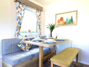 a dining room table with a blue couch at The Bay in Filey