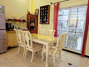 a kitchen with a dining table with chairs and a table at 城市阿瑪菲-花蓮火車站前歐風民宿 in Hualien City