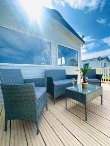 a deck with two wicker chairs and a table at The Bay in Filey