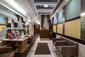 a lobby with a waiting area with couches and tables at Promenade Hotel by Mellow Mood Hotels in Budapest